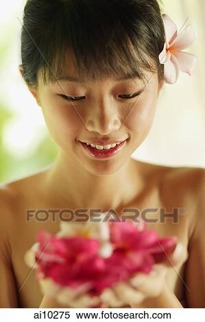Portrait of a young woman, holding flowers View Large Photo Image Stock Photography - Portrait of a young woman, holding flowers. Fotosearch