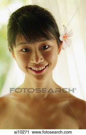 Stock Image - Portrait of a young woman, looking at camera. Fotosearch
