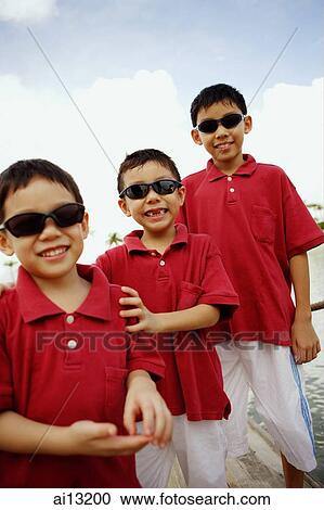 Three boys standing in a row View Large Photo Image Stock Image - Three boys standing in a row. Fotosearch