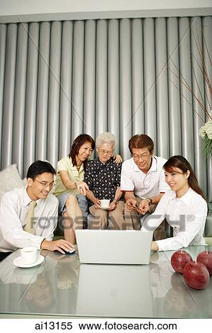 Three generation family in living room, looking at laptop View Large Photo Image Stock Photography - Three generation family in living room, looking at laptop. Fotosearch
