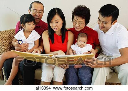 Three generation family, looking at photo album View Large Photo Image Picture - Three generation family, looking at photo album. Fotosearch