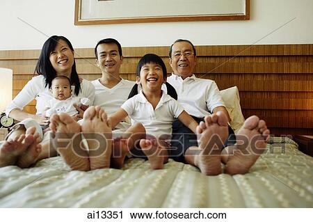 Three generation family on bed, looking at camera, low angle view View Large Photo Image Stock Image - Three generation family on bed, looking at camera, low angle view. Fotosearch