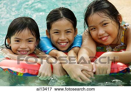 Three girls in swimming pool, looking at camera View Large Photo Image Stock Photo - Three girls in swimming pool, looking at camera. Fotosearch