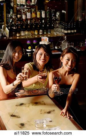 Three women sitting around table with wine glasses View Large Photo Image Stock Photography - Three women sitting around table with wine glasses. Fotosearch
