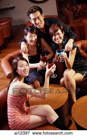 Three young women and a man in entertainment club, looking at camera View Large Photo Image Stock Photo - Three young women and a man in entertainment club, looking at camera. Fotosearch
