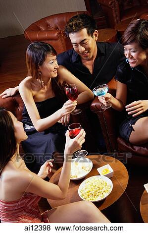 Three young women and a man in entertainment club, holding drinks View Large Photo Image Stock Photo - Three young women and a man in entertainment club, holding drinks. Fotosearch