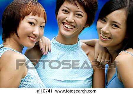 Stock Image - Three young women, side by side, looking at camera. Fotosearch