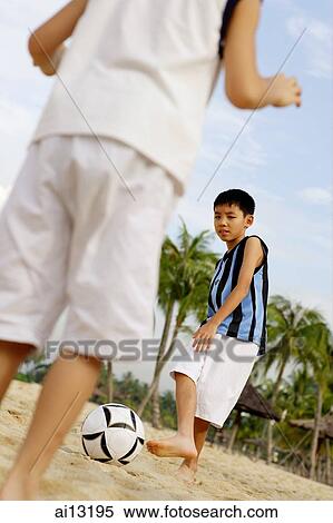 Two boys playing with soccer ball on beach View Large Photo Image Stock Photography - Two boys playing with soccer ball on beach. Fotosearch