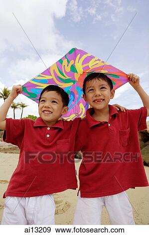 Stock Photo - Two boys standing, holding kite. Fotosearch