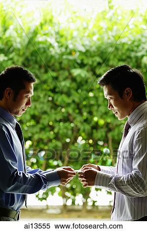Stock Photography - Two businessmen exchanging cards. Fotosearch