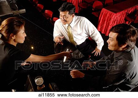 Two men at bar counter, bartender serving them View Large Photo Image Stock Photography - Two men at bar counter, bartender serving them. Fotosearch