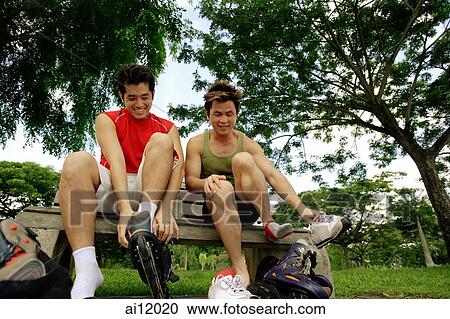 Two men on park bench, putting on roller blades View Large Photo Image Stock Image - Two men on park bench, putting on roller blades. Fotosearch