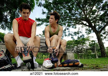 Two men on park bench, putting on roller blades, side by side View Large Photo Image Stock Image - Two men on park bench, putting on roller blades, side by side. Fotosearch