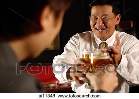 Two men toasting with beer glasses. View Large Photo Image Stock Photo - Two men toasting with beer glasses.. Fotosearch