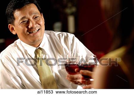 Stock Image - Two men toasting with wine glasses.. Fotosearch