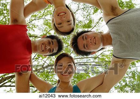 Two women and two men, arms around each other looking down at camera View Large Photo Image Stock Image - Two women and two men, arms around each other looking down at camera. Fotosearch