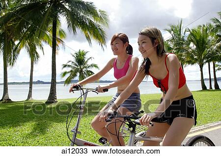 Two women on bicycles, side by side View Large Photo Image Stock Image - Two women on bicycles, side by side. Fotosearch
