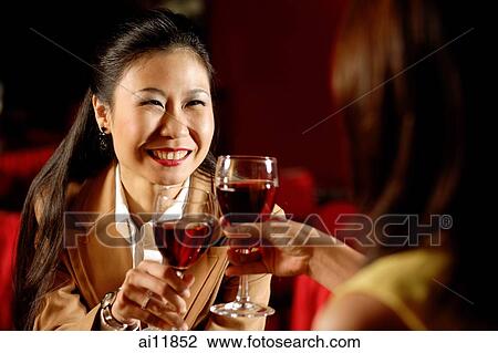 Two women toasting with wine glasses. View Large Photo Image Stock Image - Two women toasting with wine glasses.. Fotosearch