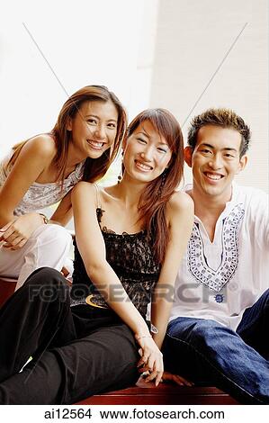 Two young women and one young man smiling at camera View Large Photo Image Picture - Two young women and one young man smiling at camera. Fotosearch
