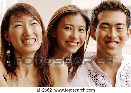 Two young women and one young man, looking at camera, portrait View Large Photo Image Stock Image - Two young women and one young man, looking at camera, portrait. Fotosearch