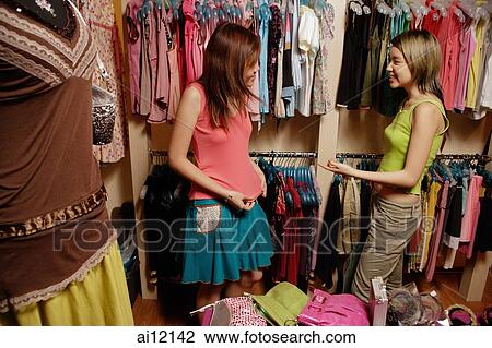 Two young women at clothes shop, shopping View Large Photo Image Stock Image - Two young women at clothes shop, shopping. Fotosearch