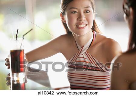 Two young women talking, face to face, drink on the table View Large Photo Image Stock Image - Two young women talking, face to face, drink on the table. Fotosearch