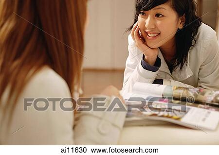 Two young women talking, face to face View Large Photo Image Stock Image - Two young women talking, face to face. Fotosearch