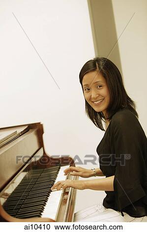 Woman at piano, looking at camera View Large Photo Image Stock Image - Woman at piano, looking at camera. Fotosearch
