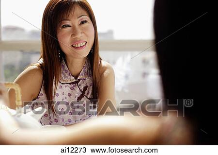 Woman facing another woman, smiling View Large Photo Image Stock Image - Woman facing another woman, smiling. Fotosearch