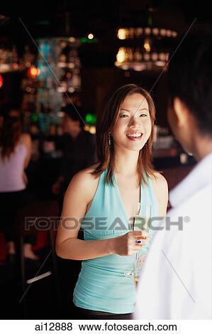 Woman facing man, holding champagne glass View Large Photo Image Stock Photo - Woman facing man, holding champagne glass. Fotosearch