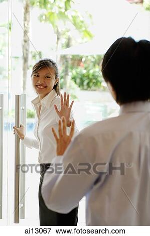 Woman holding door open, waving at man View Large Photo Image Stock Photo - Woman holding door open, waving at man. Fotosearch