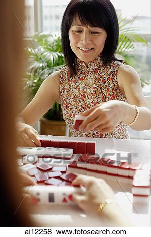 Stock Photo - Woman holding mahjong tile. Fotosearch