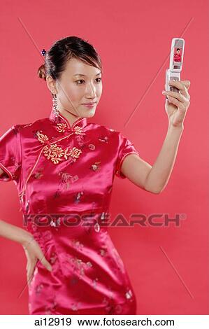 Woman holding mobile phone, hand on hip View Large Photo Image Stock Photo - Woman holding mobile phone, hand on hip. Fotosearch