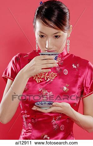 Stock Image - Woman holding teacup, drinking. Fotosearch