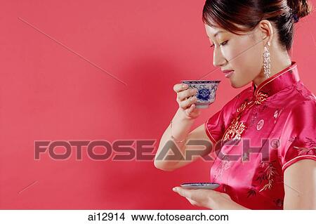 Woman holding teacup, looking down, sideview View Large Photo Image Picture - Woman holding teacup, looking down, sideview. Fotosearch