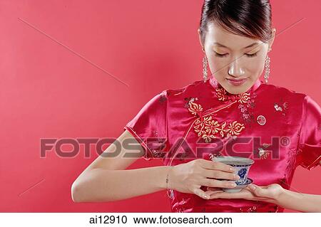 Woman holding teacup, looking down, portrait View Large Photo Image Stock Image - Woman holding teacup, looking down, portrait. Fotosearch
