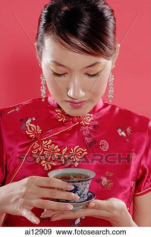 Woman holding teacup, looking down View Large Photo Image Stock Photo - Woman holding teacup, looking down. Fotosearch
