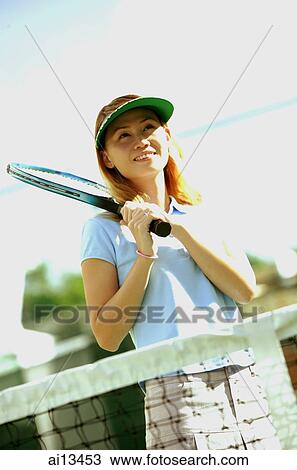 Woman holding tennis racket, looking away View Large Photo Image Stock Image - Woman holding tennis racket, looking away. Fotosearch