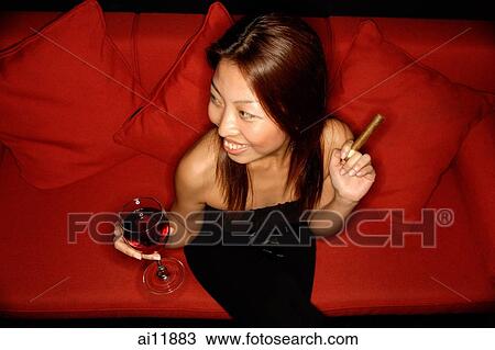 Woman holding wine glass and cigar, elevated view View Large Photo Image Stock Image - Woman holding wine glass and cigar, elevated view. Fotosearch