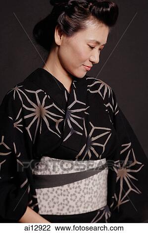 Stock Image - Woman in Japanese costume, looking down, portrait. Fotosearch