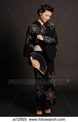 Woman in Japanese costume, standing, holding fan View Large Photo Image Stock Photography - Woman in Japanese costume, standing, holding fan. Fotosearch