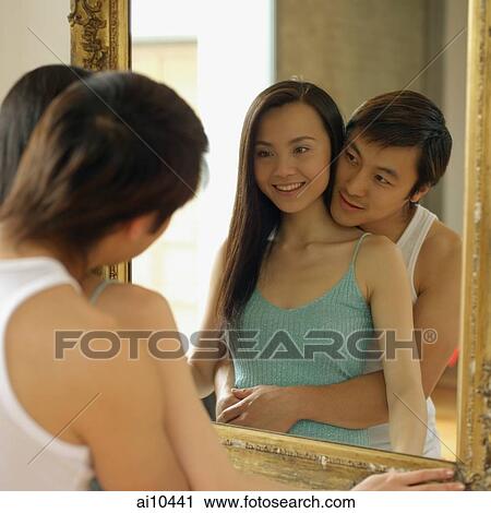 Woman looking at mirror, man hugging her View Large Photo Image Stock Image - Woman looking at mirror, man hugging her. Fotosearch