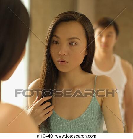 Woman looking at mirror, man watching View Large Photo Image Stock Image - Woman looking at mirror, man watching. Fotosearch