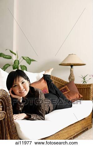 Woman lying on sofa, looking at camera View Large Photo Image Stock Photo - Woman lying on sofa, looking at camera. Fotosearch