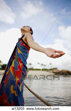 Woman on jetty, looking up, hands outstretched View Large Photo Image Stock Image - Woman on jetty, looking up, hands outstretched. Fotosearch