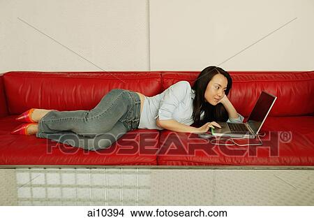 Woman on sofa, using laptop View Large Photo Image Picture - Woman on sofa, using laptop. Fotosearch