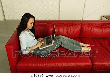 Woman on sofa, using laptop View Large Photo Image Stock Photography - Woman on sofa, using laptop. Fotosearch