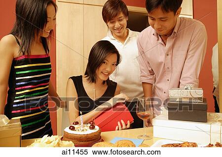 Stock Photography - Woman opening gifts, surrounded by friends.. Fotosearch
