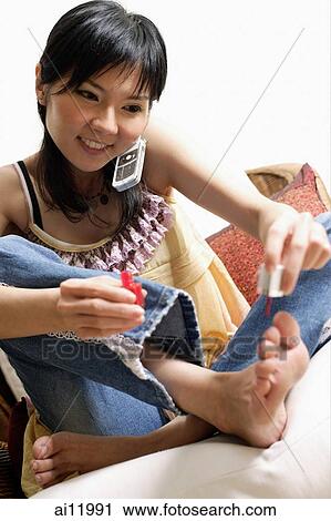 Woman painting her toenails and using the phone View Large Photo Image Stock Image - Woman painting her toenails and using the phone. Fotosearch