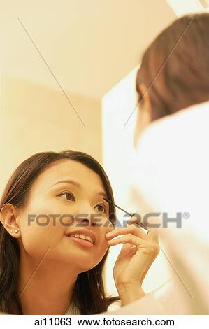Woman putting on make-up View Large Photo Image Stock Image - Woman putting on make-up. Fotosearch